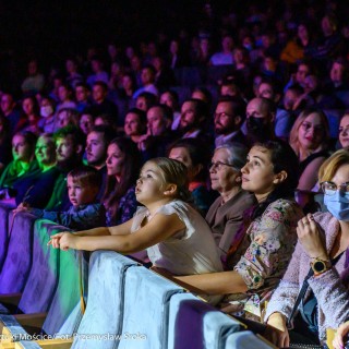 Koncert muzyki filmowej - Crushed Sounds BigBand - Ludzie siedzą na widowni i oglądają występ, niektórzy z nich mają założone maseczki na twarzach.  - Fot. Przemysław Sroka