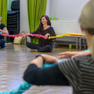 Warsztaty choreoterapii - Taniec terapeutyczny w pracy z osobami z niepełnosprawnościami. Scena Otwarta 2021 - Uczestniczki warsztatów choreoterapii siedzą w kole, trzymając w rękach kolorowy sznur. - Fot. Przemysław Sroka