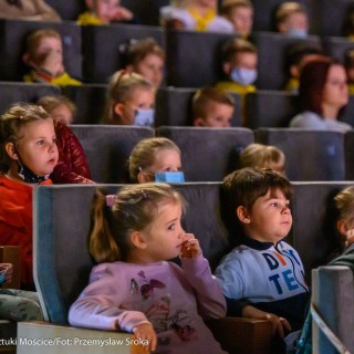 „O trzech takich, od których wszystko się zaczęło" - koncert Filharmonii Krakowskiej z cyklu "Bajki muzyką pisane" - Grupa dzieci siedzi na fotelach w sali widowiskowej i z zainteresowaniem ogląda występ. Część z nich ma założone maseczki ochronne. - Fot. Przemysław Sroka