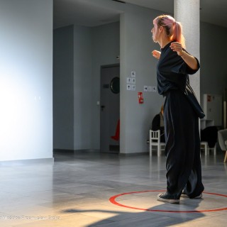 Wernisaż wystawy "Performance Dance" - Kobieta tańczy w holu, w miejscu oznaczonym czerwonym kołem z napisem "zatańcz tutaj". - Fot: Przemysław Sroka