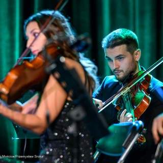 Koncert Muzyki Filmowej Maestro Krzesimira Dębskiego - Kobieta i mężczyzna grają na skrzypcach. - Fot: Przemysław Sroka