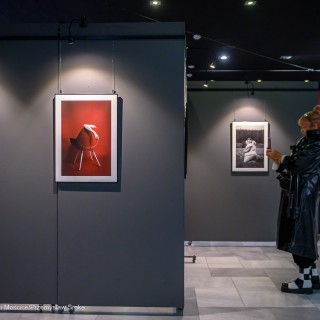 "Women" - wystawa fotografii Doroty Góreckiej - Wystawa fotografii w holu. Po prawej stronie stoi kobieta trzymająca telefon w dłoniach. - Fot: Przemysław Sroka