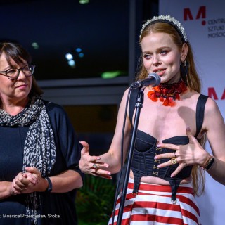 "Women" - wystawa fotografii Doroty Góreckiej - Dwie kobiety stoją obok siebie. Jedna z nich mówi do stojącego przed nią mikrofonu, druga na nią patrzy. - Fot: Przemysław Sroka