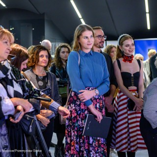 "Women" - wystawa fotografii Doroty Góreckiej - Kobiety i mężczyźni stoją w holu i patrzą w kierunku sceny. - Fot: Przemysław Sroka
