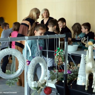 „Stroiki bożonarodzeniowe” warsztaty dla grup zorganizowanych przedszkolnych i wczesnoszkolnych - Dzieci wybierają ozdoby do stroików. Na pierwszym planie widać świąteczne dekoracje. - fot. Michał Żurowski